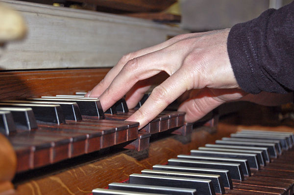 Wenn der Organist die Tasten drückt, entsteht in den Pfeifen der Orgelklang.