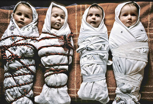 Vier albanische Babys warten auf die Befreiung. Kosovo, 1990