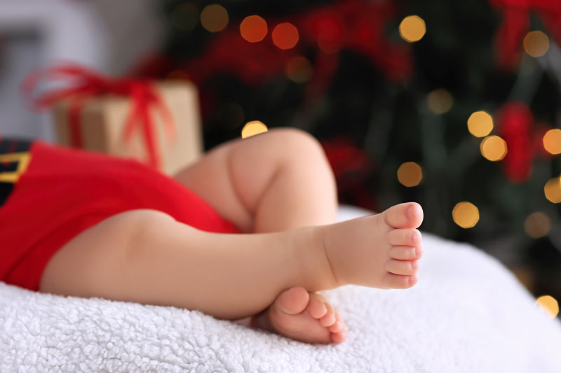 Cute little baby sleeping against blurred Christmas lights background